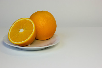Isolated oranges on plate on white background