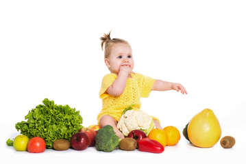 Fototapeta na wymiar Baby girl are surround of vegetables and fruits, isolated over white
