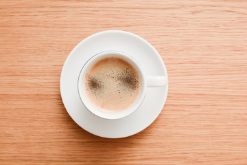 Espresso in a white cup on wooden table