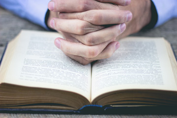 Fototapeta premium praying hands over a holy bible