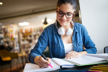 College woman studying at the library looking happy