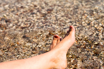 Young woman sunbathing on lounger. Legs.
