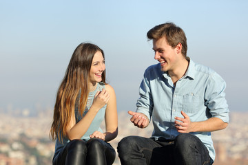 Happy couple talking in a city outskirts