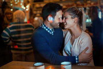 Happy couple hugging at bar and having date