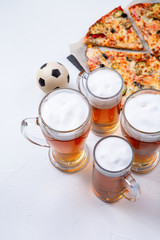 Photo from above of glasses with foam beer, pizza, pipes