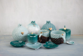 A lot of turquoise pottery on the table in gray.