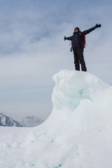 Extreme winter sports: climber reaches the top of a snowy peak in the Alps. Concepts: determination, success, strength.