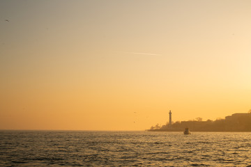 Naklejka na ściany i meble Sunset image on sea coast with buildings.