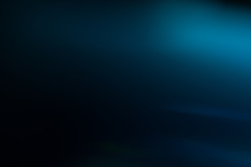 Lens flare effect. Soft defocused blurred light shine on dark blue background