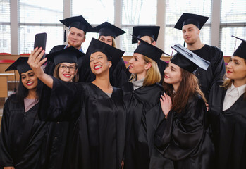 Multi ethnic group of graduated students taking selfie