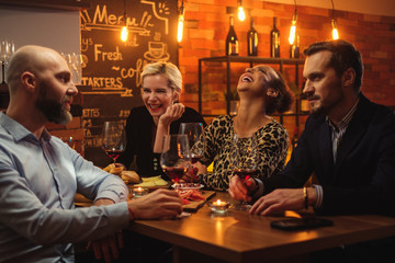 Group of friends having fun talk behind bar counter in a cafe