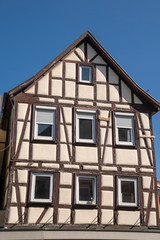 Fototapeta na wymiar beautiful detached half-timbered house in front of a blue sky