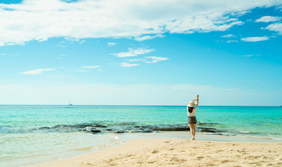 Fototapeta na wymiar Happy young woman in white shirts and shorts walking at sand beach. Relaxing and enjoying holiday at tropical paradise beach with blue sky and clouds. Girl in summer vacation. Summer vibes. Happy day.