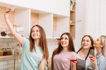 Friens gathering fun. Evening leisure relaxation. Excited young women taking selfie. Red wine in glasses.