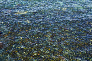 Water surface of the Atlantic ocean, stones on the bottom, sea