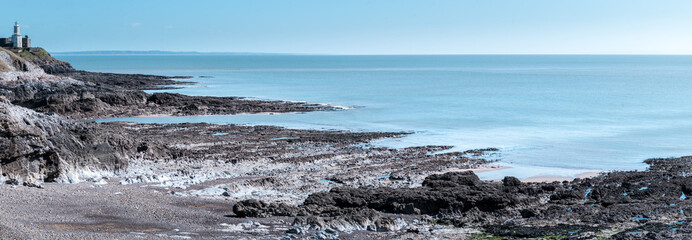 Panoramic view of a lighthouse and rocky coastline