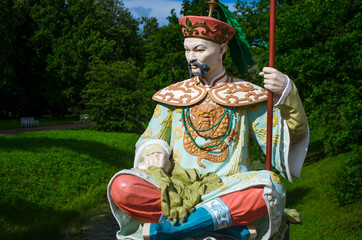 Brightly painted Chinese sculpture in national clothes. Catherine Park in the city of Pushkin.