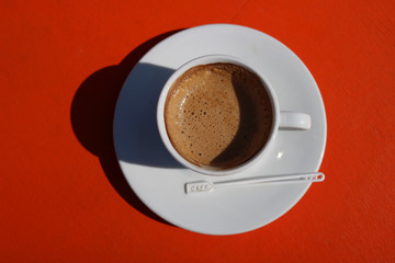 Hot coffee on red wood background