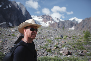 Portrait of a man in sunglasses and a hat with a walkie-talkie. Extreme trip to the mountains