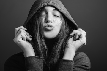 Happy youth. Affection. Cute young woman with closed eyes and pout lips blowing kiss. Black and white portrait.