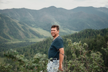 Portrait of a happy man on a mountain view background. The journey to the mountains © olga_polyanskaya