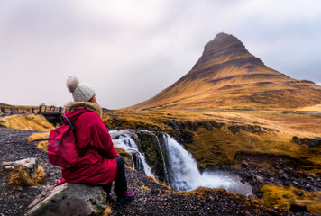 Fototapeta premium Traveler at famous Kirkjufellsfoss waterfall in Iceland