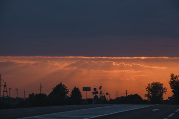 Bright red sunset over the track. Road to the city