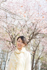 桜の前で微笑む女性