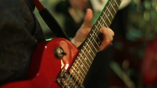 A man playing electric guitar close up