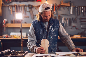 Male carpenter working on old wood in a retro vintage workshop.