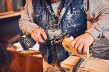 Male carpenter working on old wood in a retro vintage workshop.