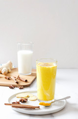 Vertical shot.Preparation of golden milk with spieces.Morning light at the kitchen.Healthy breakfast without coffee