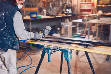 Male carpenter working on old wood in a retro vintage workshop.