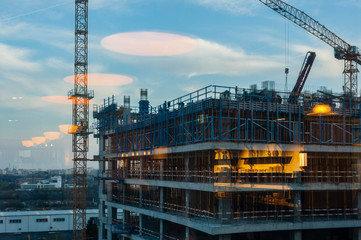 Offices building under construction seen from a neighboring building with reflections from inside the space.
