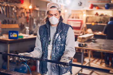 Male carpenter working on old wood in a retro vintage workshop.