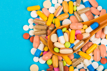 set of multi-colored tablets and capsules on a blue background