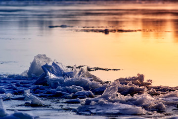 Ice on the river during the ice drift lit by the setting sun in the spring