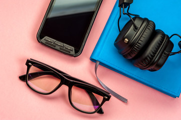 Black stylish headphones on pink background.