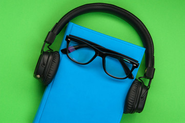 Black stylish headphones on green background.