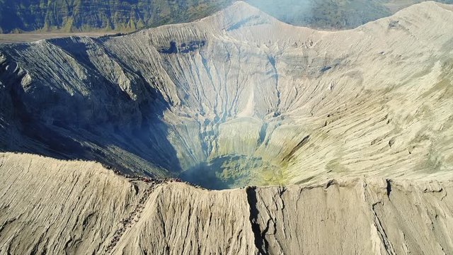 Fly over shot revealing the massive crater of Mount Bromo,  an active volcano in East Java, Indonesia
