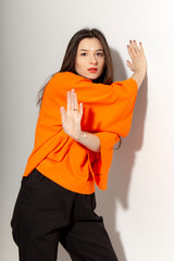 People, youth, leisure and lifestyle concept. Fashionable Caucasian young female student wearing stylish clothing laughing happily, having fun in photo studio. Copy Space