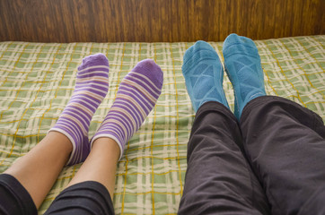  legs with socks of a couple in bed
