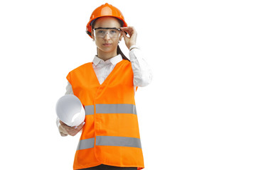 Destroying gender stereotypes. Female builder in orange helmet standing on white studio background....
