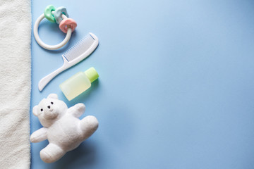 Baby shower flat lay on blue background. child toys and shampoo. copy space. place for text