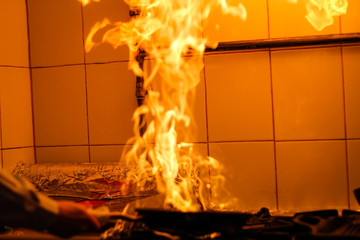 The chef cooking and makes a fire in a pan. Cooking with fire. Crown food. Charismatic chef in the...