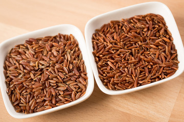 Rotschaliger roher roter Reis aus Piemont Italien und roter Jasmin Reis aus Kambodscha Asien in Porzellan Schale sind Spezialitäten