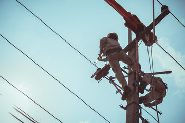 Two linemans use devices that are insulated for maintenance high voltage distribution system. To...