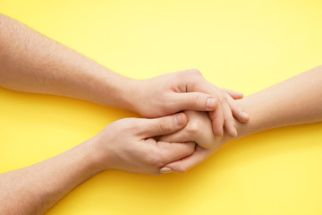 Man holding hand of young woman on color background - obrazy, fototapety, plakaty
