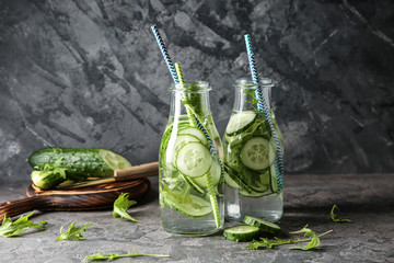 Bottles of cucumber water on grey table