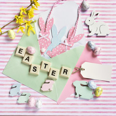 easter flat lay with bunny decors in envelope on striped background